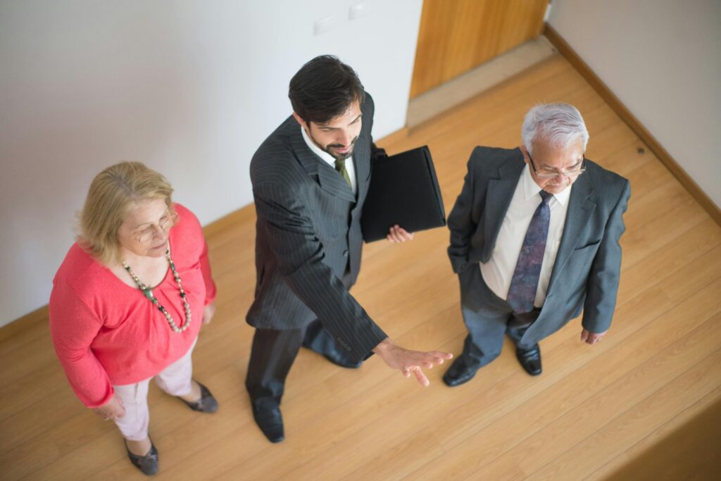 An older couple talking with a commercial real estate adviser - How to Use Bridging Finance to Buy a Property at Auction